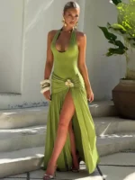 Elegant green dress with high slit, floral detail, and stylish accessories.