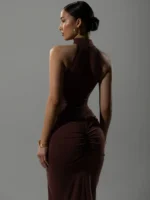 Elegant woman in a dark brown dress, back view, studio shot.