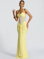 Woman in elegant yellow maxi dress with halter top and ruched details.