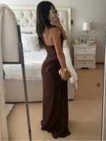 Elegant woman in brown evening gown taking mirror selfie at Thrive Store.