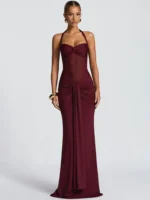 Woman wearing a burgundy maxi dress with spaghetti straps and ruched details.