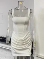 White fitted dress displayed on a clear mannequin for fashion showcase.
