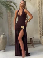 Elegant black evening dress with high slit and floral embellishment.