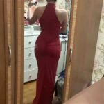 Elegant woman in a red dress taking a mirror selfie at Thrive Store.