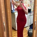 Woman taking mirror selfie in red dress at Thrive Store.