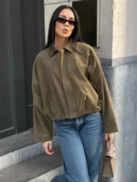 Casual woman's fashion in oversized brown jacket and blue jeans, modern streetwear style.